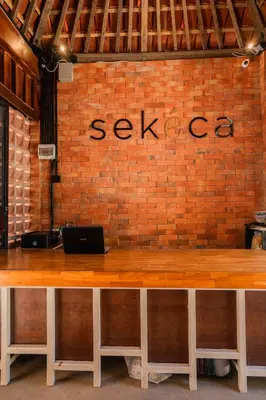 a brick wall with a table with a laptop on it at Kuta Sekeca CoWorking Apartment Close to Kuta Beach in Jimbaran