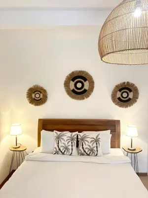 a bedroom with a bed with white sheets and pillows at Villa Vela 6 BR Seminyak in Seminyak