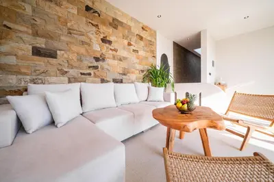 a living room with a white couch and a brick wall at New Luxury villa walk to Atlas, Finns and Berawa beach in Canggu