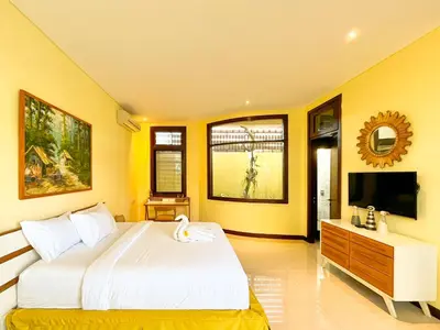a bedroom with a large bed and a tv at Villa Michelle Bali in Seminyak
