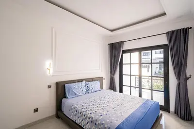 a bedroom with a bed and a large window at Aurelia Home at Mogan Residence in Seminyak