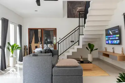 a living room with a couch and a staircase at Serayu Mertanadi by Bukit Vista in Seminyak