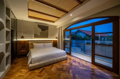 a bedroom with a bed and a large window at Sonaa Villa Bali in Canggu