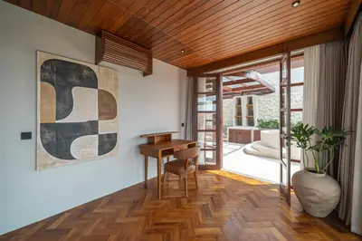 a living room with a wooden ceiling and a desk at Sonaa Villa Bali in Canggu