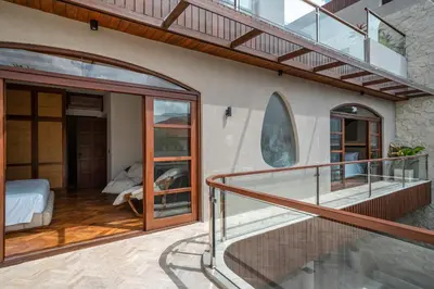 a balcony with glass doors and a bed in a room at Sonaa Villa Bali in Canggu