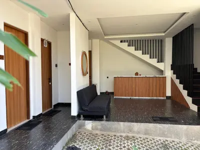 a waiting room with a black chair and stairs at Taman Sari Guesthouse in Kerobokan