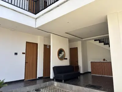 a living room with a blue couch and stairs at Taman Sari Guesthouse in Kerobokan