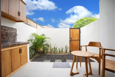a kitchen with a view of a courtyard with plants at Abimanyu Guest House in Seminyak