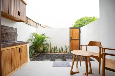 a kitchen with a table and a stool on a patio at Abimanyu Guest House in Seminyak