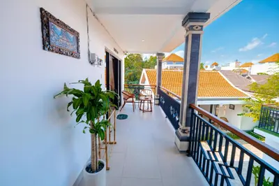 a balcony of a house with a plant at Crystal Flow Guest House & Apartment Canggu in Canggu