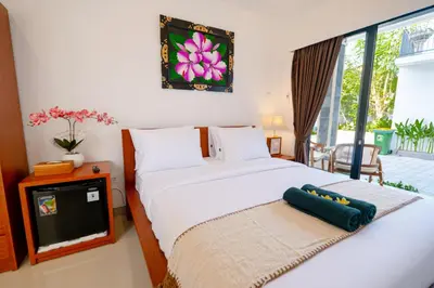 a bedroom with two beds and a tv in it at Crystal Flow Guest House & Apartment Canggu in Canggu