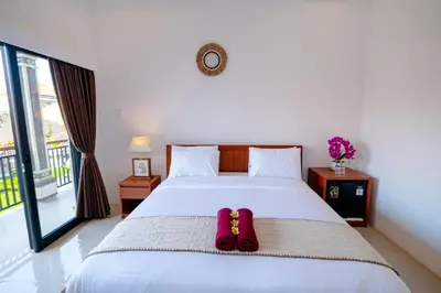 a bedroom with a bed with two slippers on it at Crystal Flow Guest House & Apartment Canggu in Canggu
