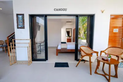 a room with a bedroom with a bed and a table at Crystal Flow Guest House & Apartment Canggu in Canggu