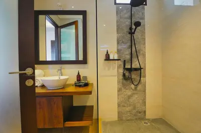 a bathroom with a sink and a mirror and a shower at Luxury Villa 3br 5min to Seminyak beach in Seminyak