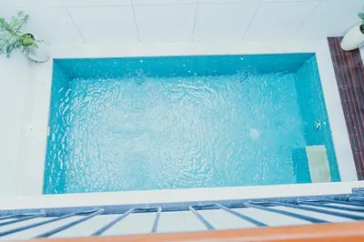 a swimming pool with blue water in a room at Brand New! Villa Putu Seminyak in Kerobokan