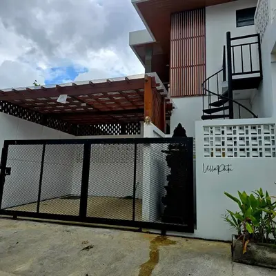 a black gate in front of a white building with a patio at Brand New! Villa Putu Seminyak in Kerobokan