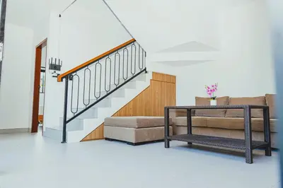 a living room with a couch and a staircase at Brand New! Villa Putu Seminyak in Kerobokan