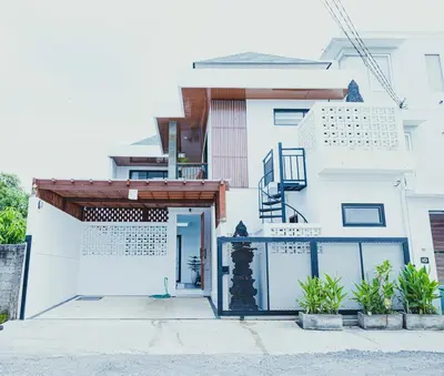 a white house with a gate and a door at Brand New! Villa Putu Seminyak in Kerobokan