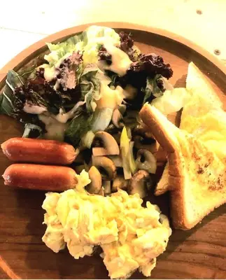 a plate of food with sausage and vegetables and bread at Villa Diraya 2 Bedroom Villa in Kerobokan in Kerobokan