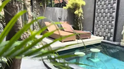 a bench sitting next to a swimming pool at Villa Diraya 2 Bedroom Villa in Kerobokan in Kerobokan