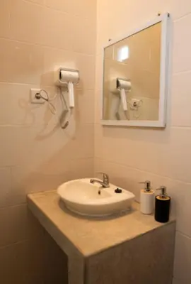 a bathroom with a sink and a mirror at GB UNLU Villas in Kerobokan