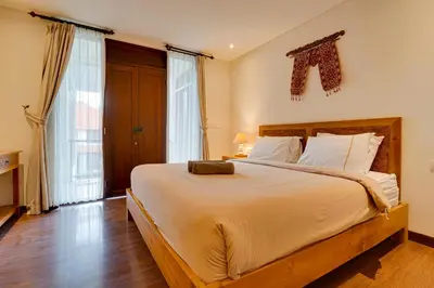 a bedroom with a large bed with white sheets at Family 3BR Villa Laviosa in Petitenget near Beach in Seminyak