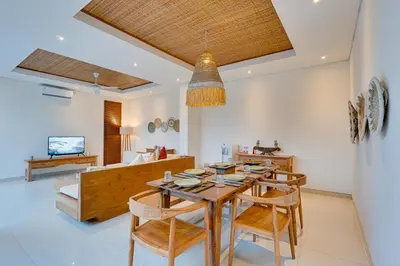 a dining room with a wooden table and chairs at Family 3BR Villa Laviosa in Petitenget near Beach in Seminyak