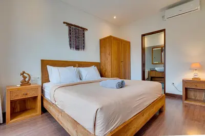 a bedroom with a large bed and a mirror at Family 3BR Villa Laviosa in Petitenget near Beach in Seminyak