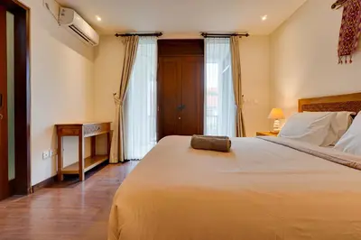 a bedroom with a large bed and a window at Family 3BR Villa Laviosa in Petitenget near Beach in Seminyak