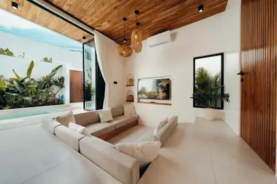 a living room with white furniture and large windows at La Payesa 2 in Canggu