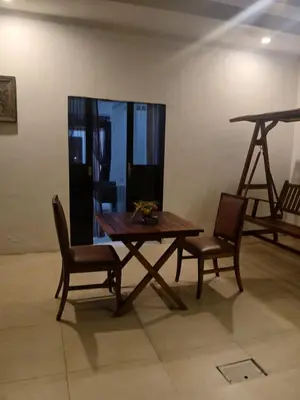 a wooden table and two chairs in a room at Villa Private In Kuta Bali in Kuta