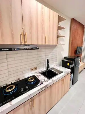 a kitchen with a sink and a stove top oven at Luminera Bali Apartment in Nusa Dua