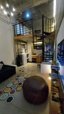 a living room with a large brown ottoman on the floor at Arzella Apartment in Seminyak
