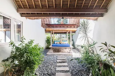 a courtyard with a blue bed in a house at Five Star Reviews, Airbnb Plus, Awesome Location in Seminyak