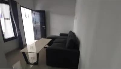 a living room with a black couch and a table at Omah Chandra in Pesanggaran