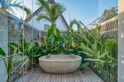 a bath tub in a room with plants at New Sleek 1BR Retreat with Pool Near Seminyak in Kerobokan