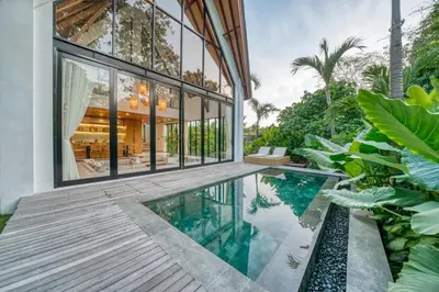 an external view of a house with a swimming pool at New Tranquil Jungle View Villa in Kerobokan in Kerobokan