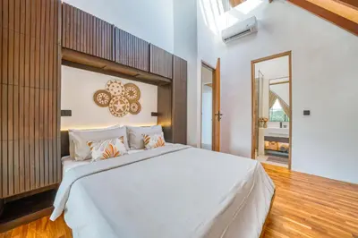 a bedroom with a white bed and a mirror at New Tranquil Jungle View Villa in Kerobokan in Kerobokan