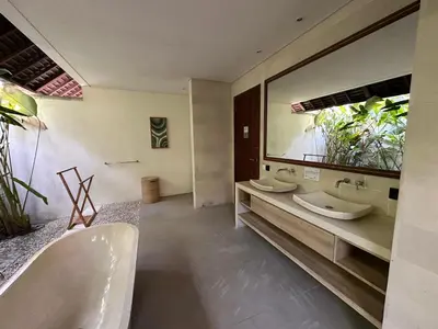 a bathroom with two sinks and a large mirror at Saba Villas in Canggu