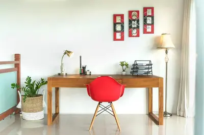 a red chair sitting in front of a wooden desk at 5 Reviews, Huge Savings Best Locale In Seminyak in Badung