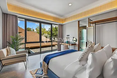a bedroom with a large bed and a large window at Andra Villa by Kozystay - Natadesa Resort Jimbaran in Jimbaran