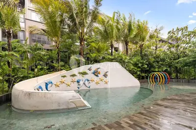 a slide in the middle of a swimming pool at Caraya by Kozystay - Nusa Dua in Nusa Dua