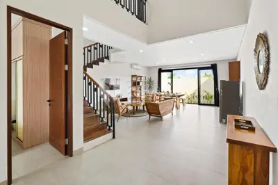 a living room with a staircase and a dining room at Manisha Villa by Kozystay - Seminyak in Seminyak