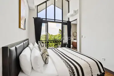 a bedroom with a bed with a window at Manisha Villa by Kozystay - Seminyak in Seminyak