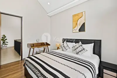 a white bedroom with a bed and a table at Manisha Villa by Kozystay - Seminyak in Seminyak