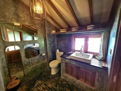 a bathroom with a sink and a toilet in a room at Villa Hibou - New Tropical Luxury 2BR near Canggu in Canggu
