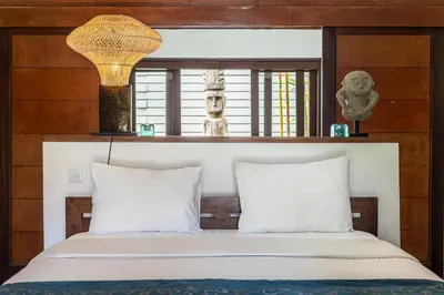 a bedroom with a bed with white pillows and a lamp at Seminyak Most Wanted Villa for family vacation in Seminyak