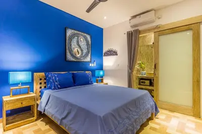 a blue bedroom with a bed and a blue wall at Villa Josefine, 5 Bedroom pool, rooftop, pool table in Seminyak