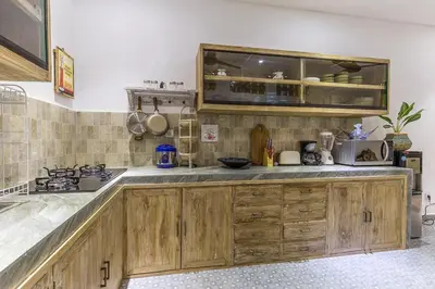 a kitchen with wooden cabinets and a counter at Villa Josefine, 5 Bedroom pool, rooftop, pool table in Seminyak