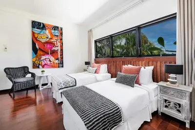 a bedroom with two beds and a window at Villa Drupadi 16 in Seminyak